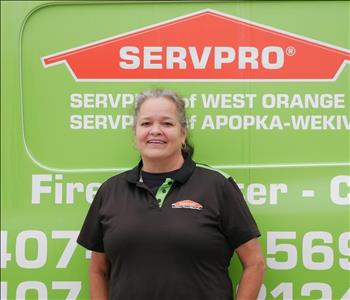 Female employee in front of service truck.